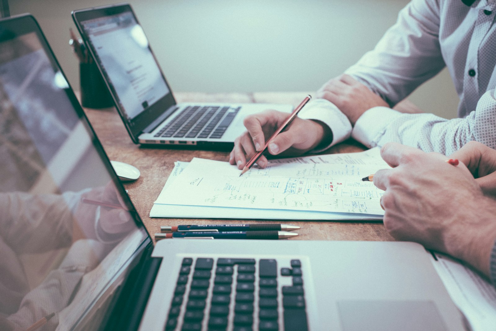Independent consultant reviewing a financial plan on a laptop beside a paper notebook